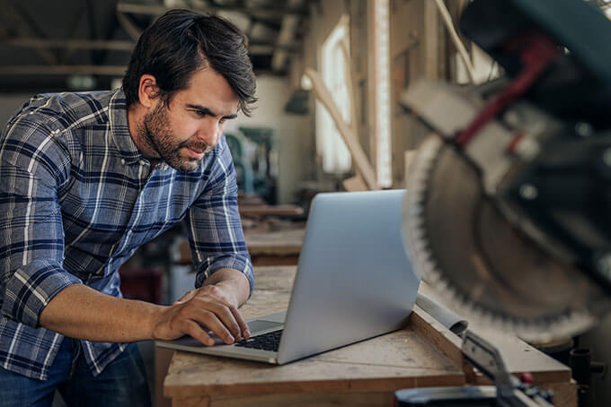 Business owner using Synoptic ERP on a laptop in his workshop