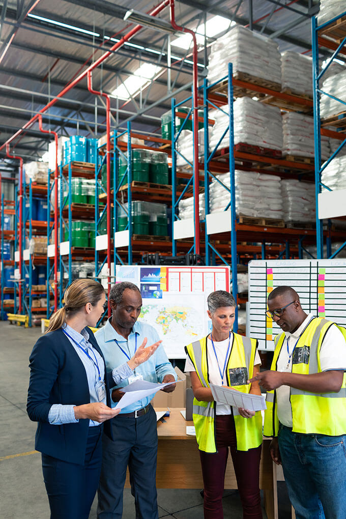 Équipe logistique faisant le point dans un entrepôt avec rayonnages