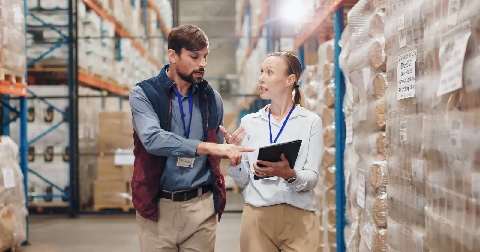 Responsable logistique et collaboratrice munie d'une tablette préparant l'inventaire de fin d'année dans un entrepôt