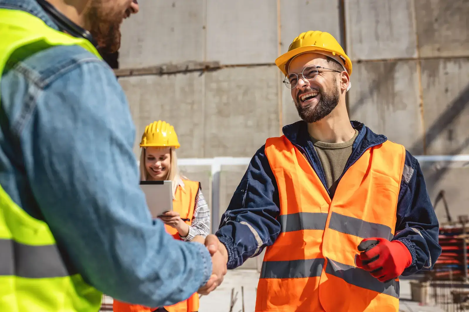 Poignée de main entre un client industriel et un chef de projet sur un site de production
